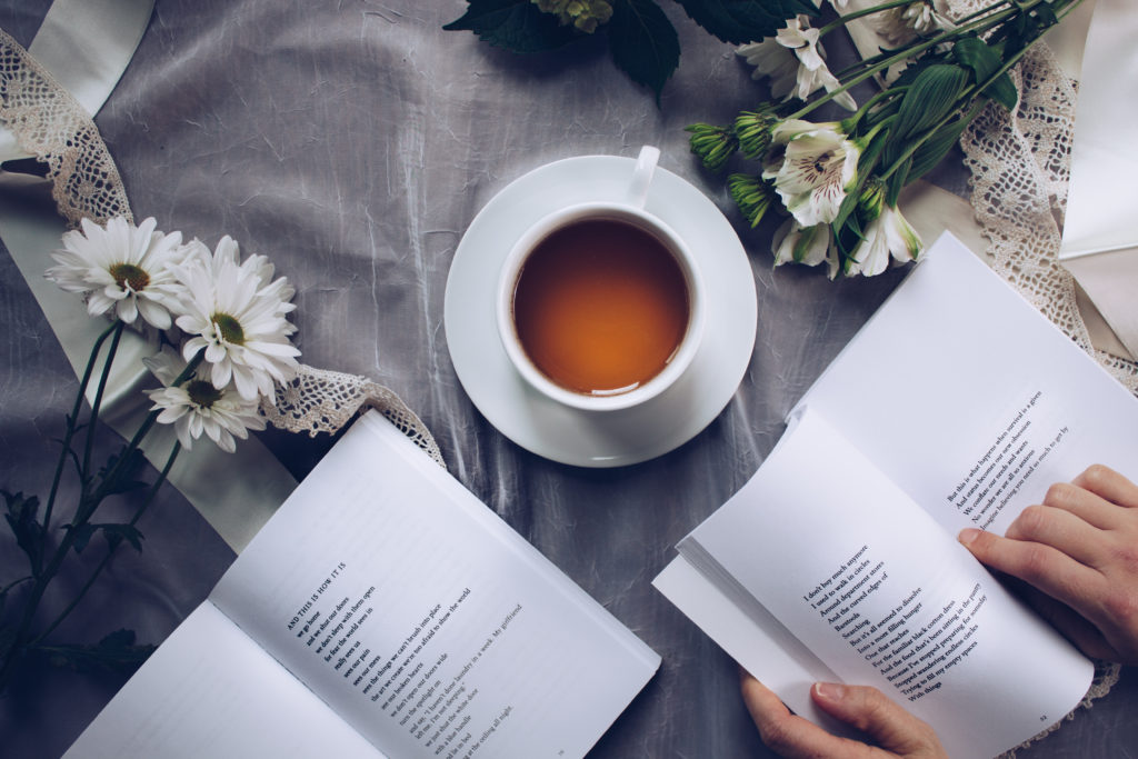 A cup of tea, flowers and someone reading a questionnaire part of the article Life Purpose: How to find your purpose in life.